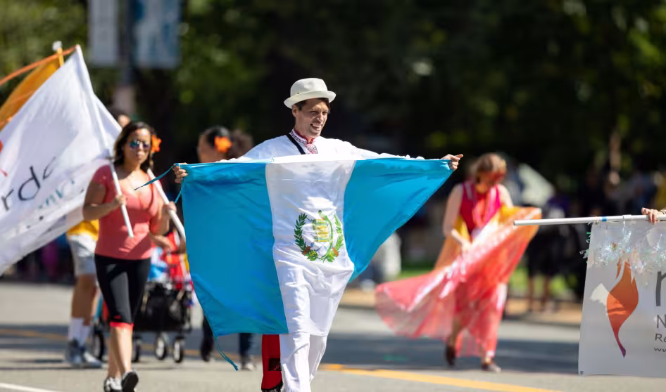 A man carrying the flag of Guatemala in a parade in Washington, DC.