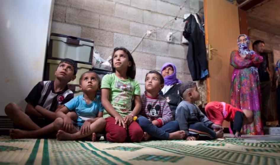 Children and women gaze off in a house