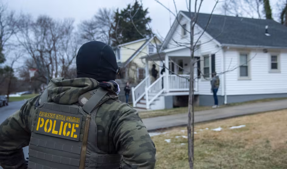 An ICE officer outside a home in Baltimore, Maryland.