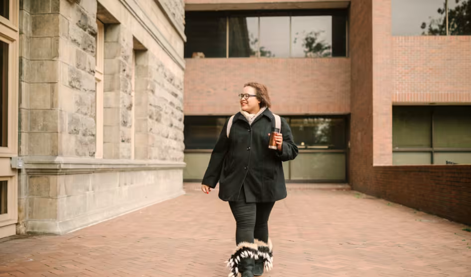 Photo of woman walking around a school campus.