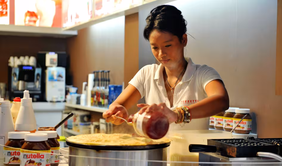 Image of female worker at the Boqueria market in Barcelona making a crepe