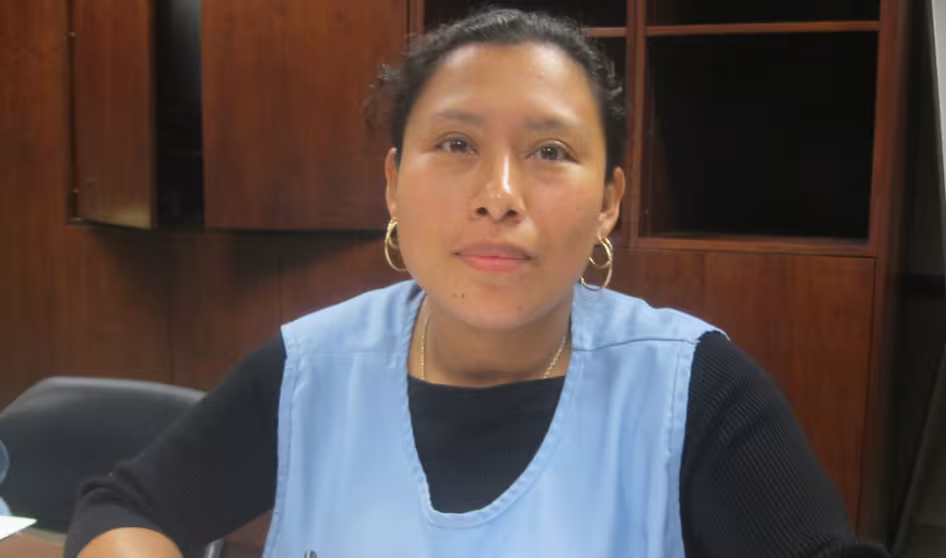 Woman in blue smock sitting at table