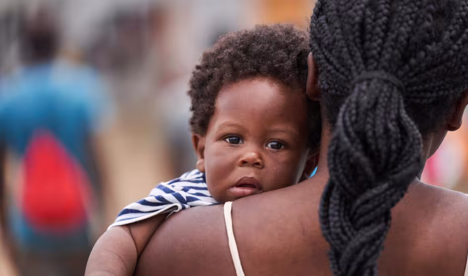 A Haitian child looks over his mother's shoulder in Panama
