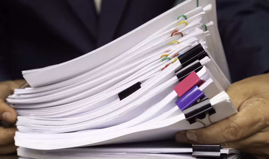 Worker holds stack of paperwork