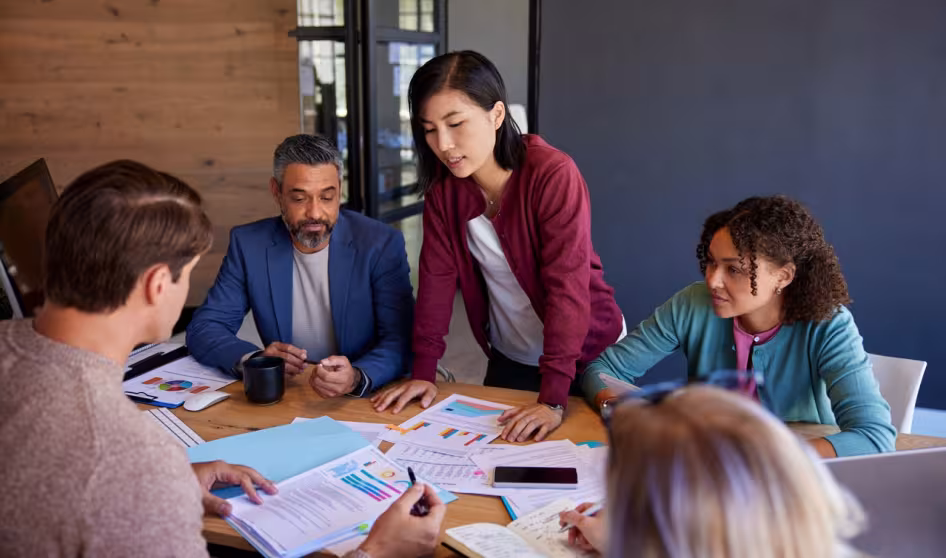 Male and female business professionals gathered at a conference table