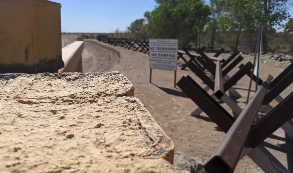 Fencing and a "no trespassing" sign at the U.S.-Mexico border