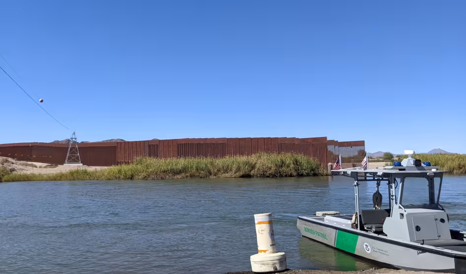 Image of U.S.-Mexico border wall and Border Patrol boat