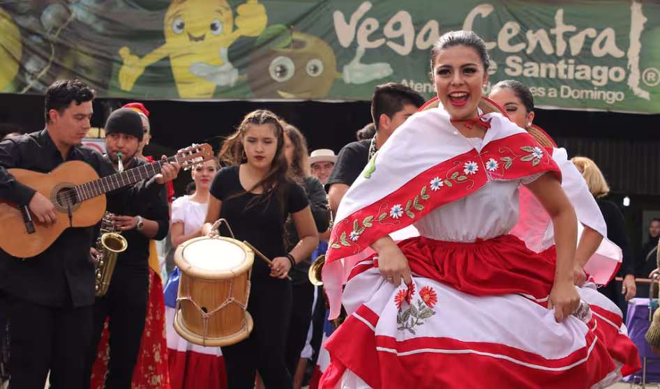 Migrants and natives dance at a multicultural celebration in La Vega, Chile.