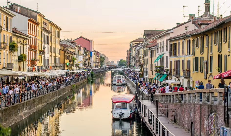 Crowds of people walk along the canal in Milan