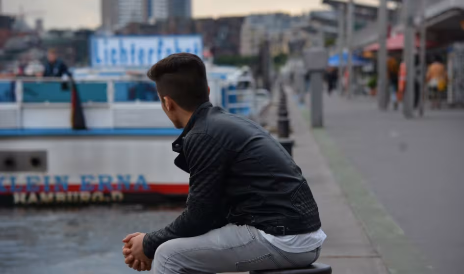 A refugee looks out over Hamburg harbor