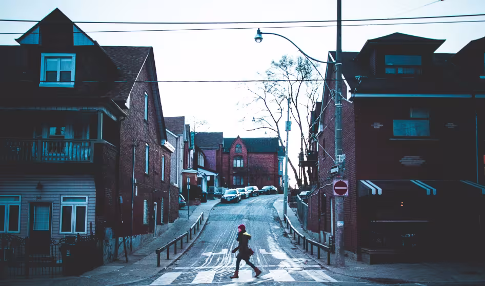 Woman walks across a street in a Toronto neighborhood