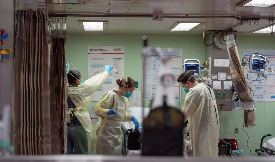 Three health professionals wearing masks in a hospital