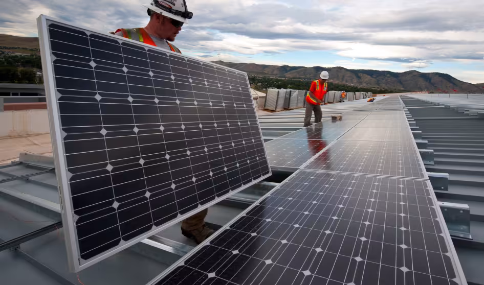 Workers install solar panels