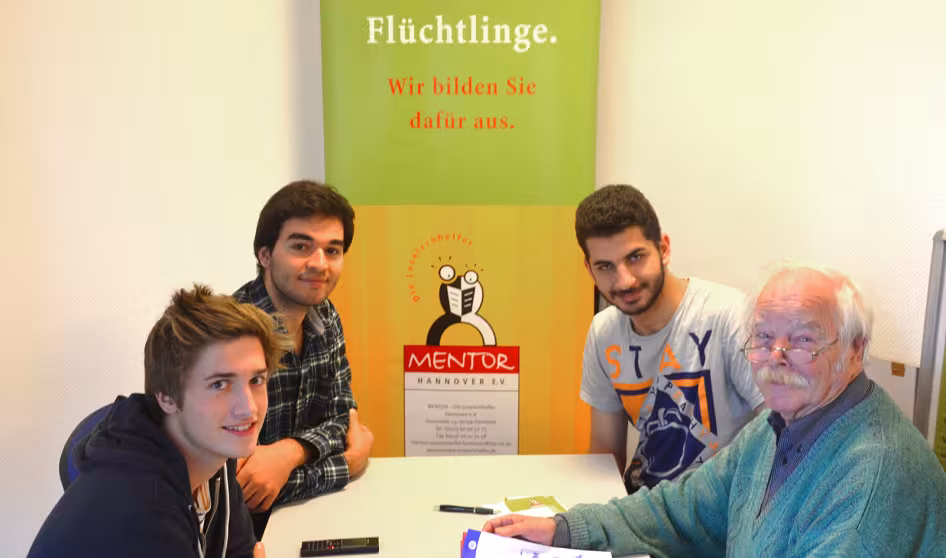 Syrian refugees meet with volunteers at a German for Refugees program.