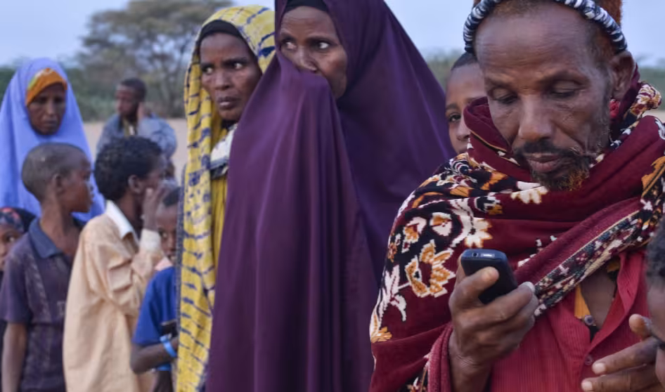 A refugee texts while waiting to register at Ifo refugee camp in Dadaab, Kenya.