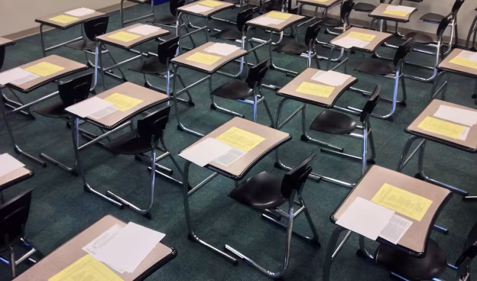 A classroom with exam papers on students' desks