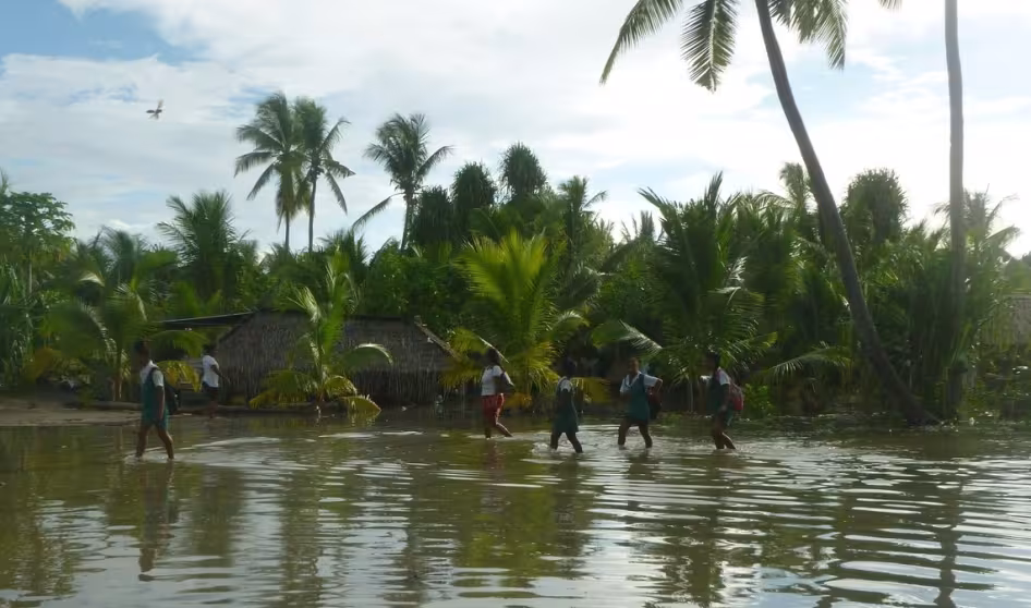 People walk through a flooded area in Kiribati