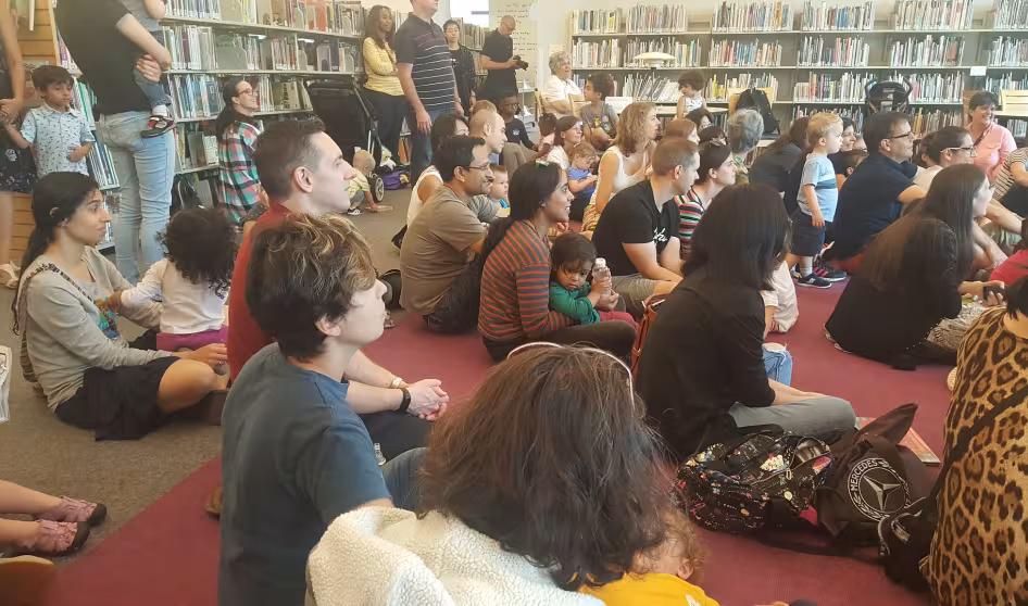 Parents and their children sit in a library for Princeton Children's Book Festival 2018
