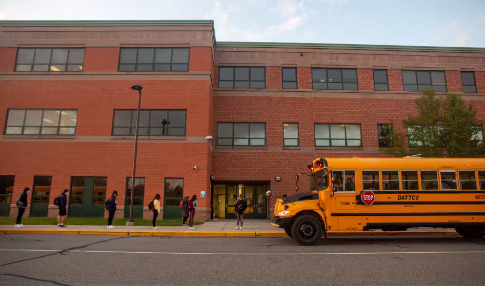 Students lined up outside their high school at the start of the school day.