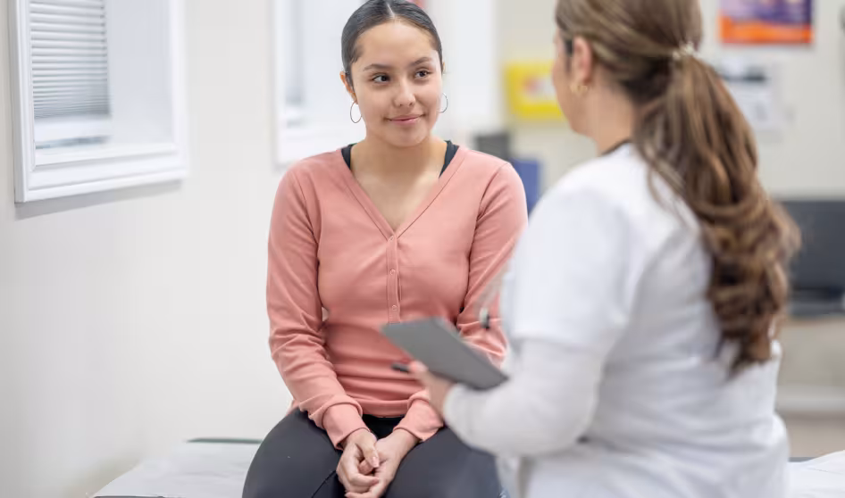 Latina teenager in medical office with clinician