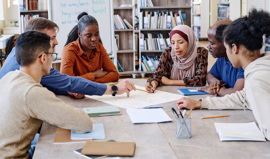 Adult immigrant students work together in an English class