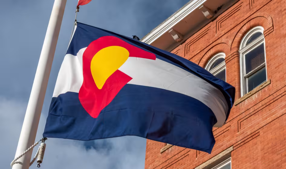 Colorado flag in front of a brick building