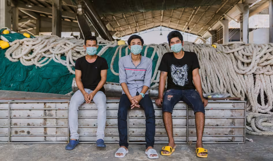 Three migrant men wearing masks in Thailand