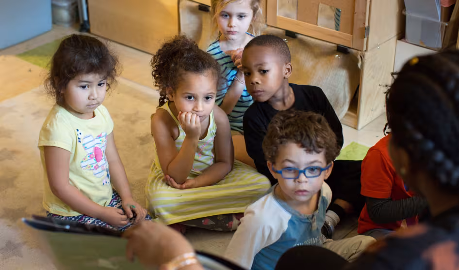 A group of preschoolers listen to a story