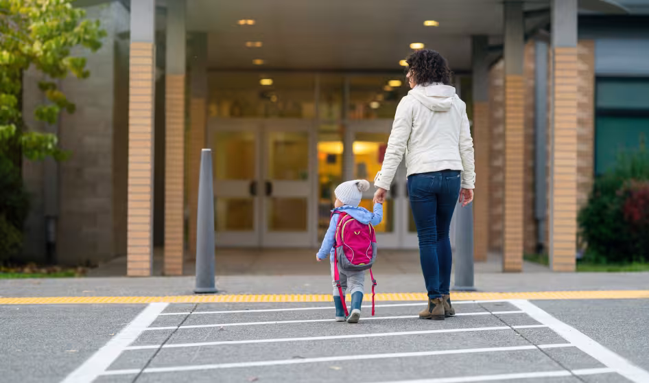A mother and toddler walking into a school