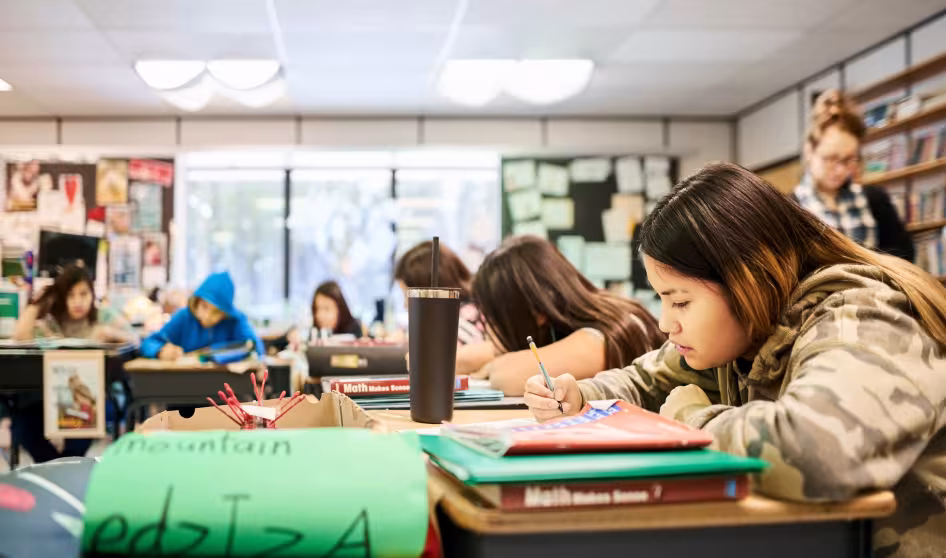 Children in a classroom writing at their desks