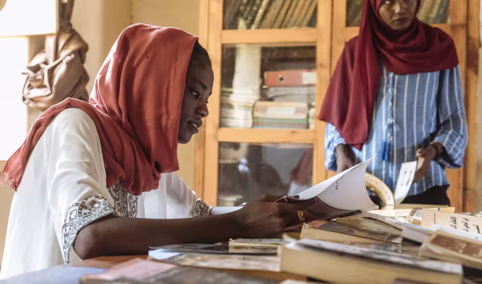 Two women at a Sudanese community center rehabilitated by IOM and a local NGO