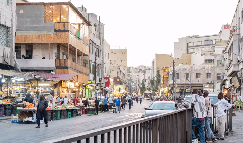 A street in Amman, Jordan, with market stalls, people, and cars
