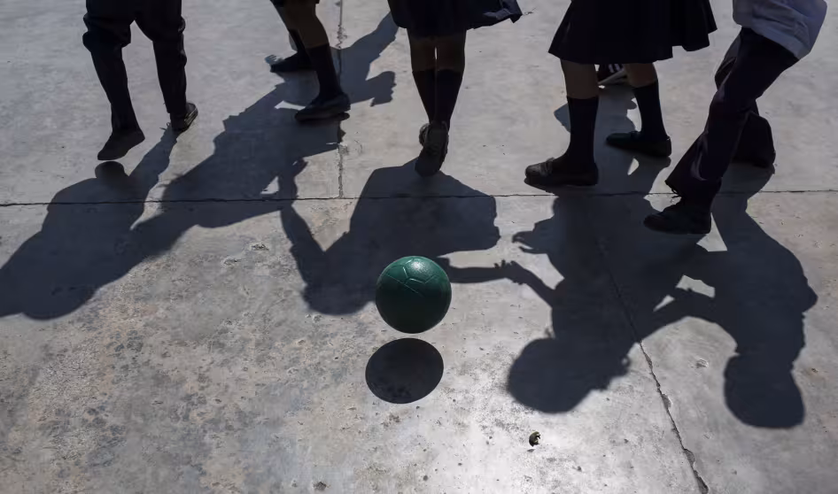 Children at a school in Honduras play with a soccer ball