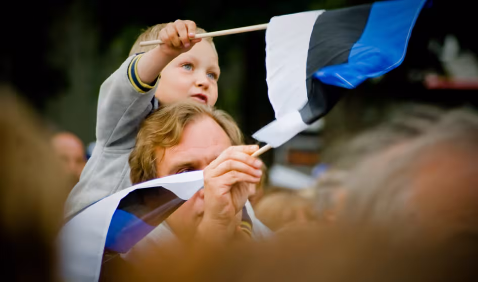 A father and son wave flags at the Estonian Song Festival in Tallinn.