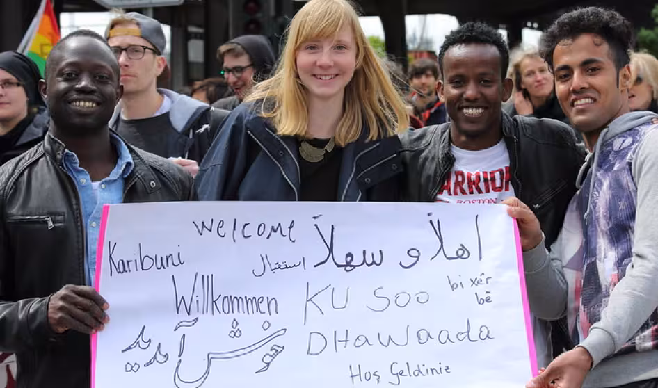 Four people stand with a sign at a demonstration