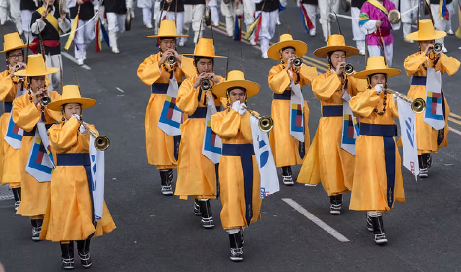 Korean band members march in a parade