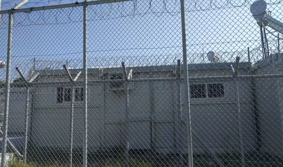 Buildings behind a barbed wire fence