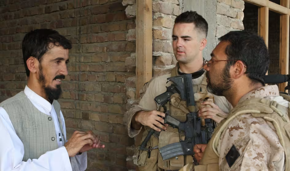 An Afghan man speaks to an interpeter working with the U.S. Marine Corps.