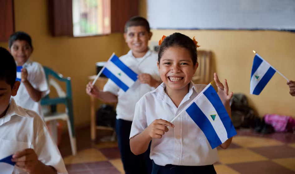 Ni&ntilde;os nicarag&uuml;enses en la escuela sosteniendo la bandera de su pa&iacute;s. 