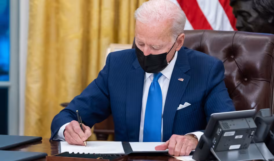 President Joe Biden signs executive orders on immigration in the White House.