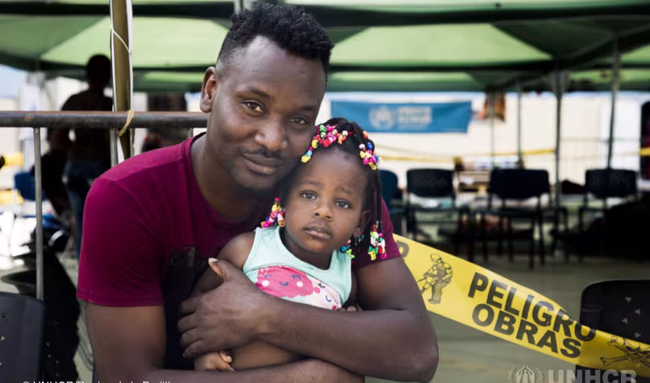 A Haitian man hugs his daughter in Peru.