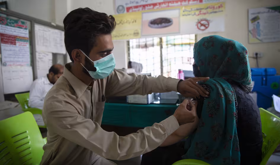 An Afghan refugee receives a COVID-19 vaccination in Pakistan.