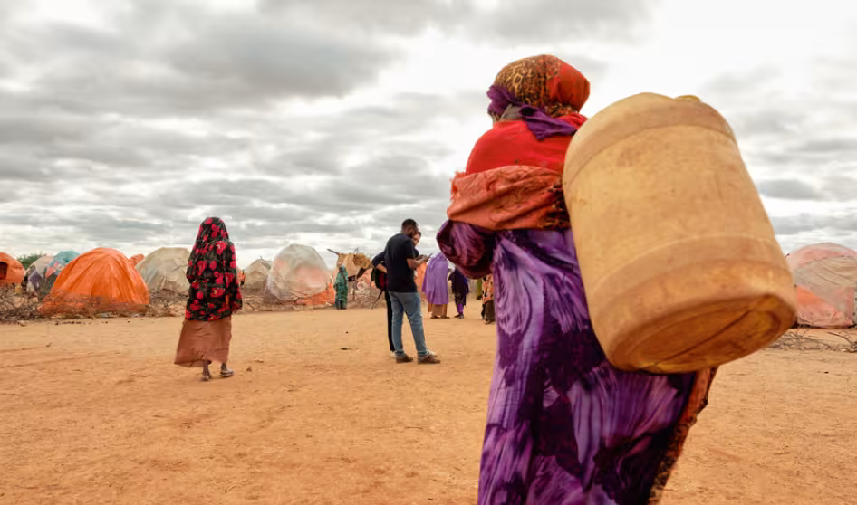 A displaced woman walks with a jerrycan of water in Somalia.
