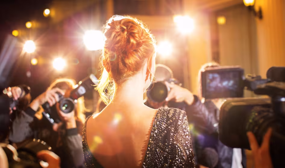 A female celebrity being photographed at an event.