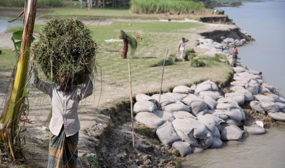 A man walks through a community affected by river erosion in Bangladesh.