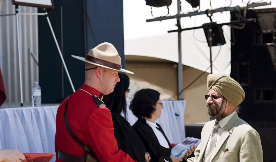 A new Canadian citizen greets a Royal Canadian Mounted Police officer at a citizenship ceremony