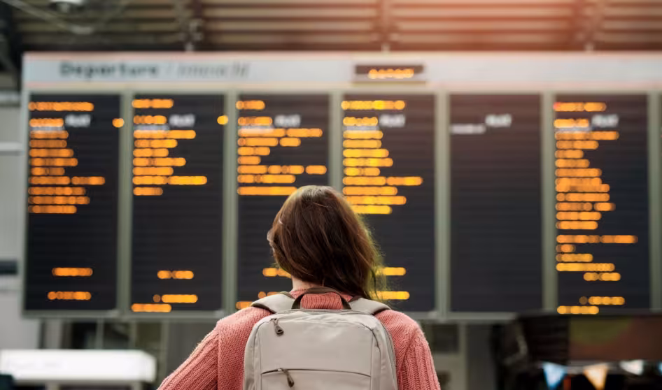 A woman at an airport looks at flight information