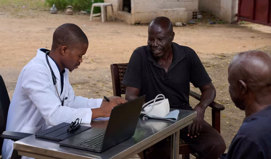 A doctor talks to a patient in Nigeria.