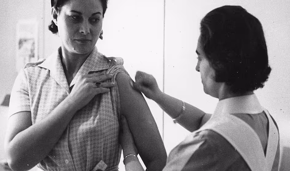A woman in Italy is vaccinated before travel in 1951.