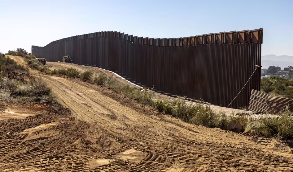 A construction crew works on a wall the U.S.-Mexico border.